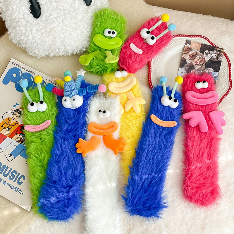 Colorful collection of funny monster fleece winter socks in various designs and vibrant colors on a cozy background.